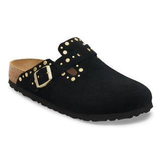 Black clog shoe with gold buckle and studs on a white background
