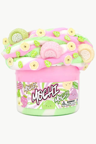 Pink and green mochi toy with decorative elements on a white background