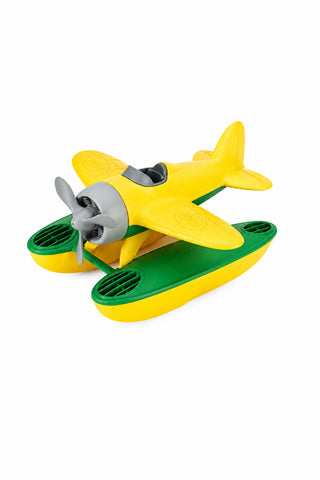 A yellow and green toy seaplane with a spinning propeller and large pontoons designed to float on water.