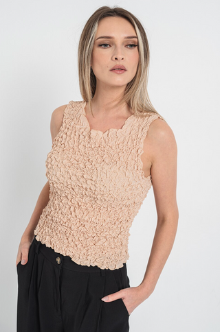 Woman wearing a wrinkled sleeveless tan top from Vero Moda Clothing Company