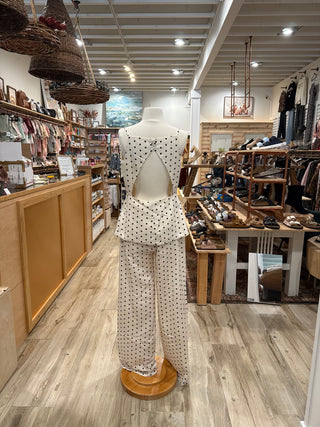 Mannequin wearing a polka dot dress jumpsuit with open back.