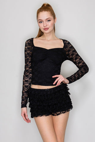 Woman wearing a black lace top featuring womens top from Iris