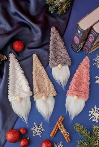 A collection of gnome wine hats with beige, brown, and pink color schemes, displayed on a table with a blue cloth.