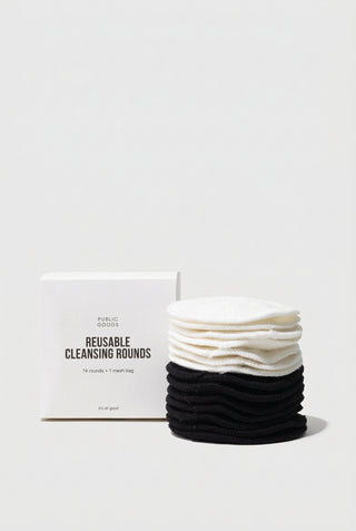 A stack of black and white reusable cleansing rounds next to their packaging box.